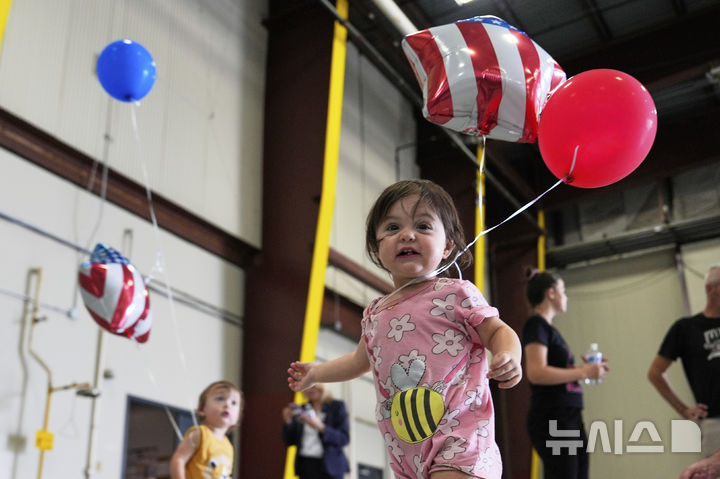 [덜레스=AP/뉴시스] 미국 국기를 든 남아프리카공화국계 아프리카너들이 12일(현지 시간) 미 버지니아주 덜레스에 있는 덜레스 국제공항에 도착하고 있다. 이날 아프리카너(16세기 이후 네덜란드 등 유럽에서 남아공으로 이주해 정착한 백인) 59명이 난민 자격으로 미국에 입국했다. 취임 뒤 사실상 난민 수용을 중단한 도널드 트럼프 행정부가 남아공 백인의 난민 지위를 인정해 미국 내 정착을 허용해 논란이 일고 있다. 2025.05.13.