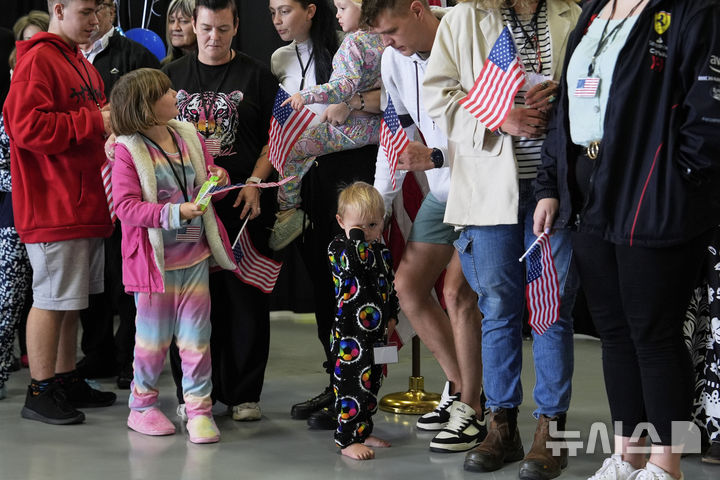 [버지니아=AP/뉴시스]=남아프리카공화국 출신의 아프리카너 난민들이 미국 국기를 들고 2025년 5월 12일 월요일, 버지니아주 덜레스에 위치한 덜레스 국제공항에 도착하고 있다. 2025.05.13.