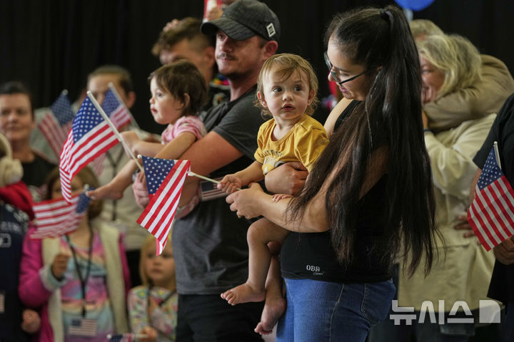 [버지니아=AP/뉴시스]=남아프리카공화국 출신의 아프리카너 난민들이 미국 국기를 들고 2025년 5월 12일 월요일, 버지니아주 덜레스에 위치한 덜레스 국제공항에 도착하고 있다. 2025.05.13.