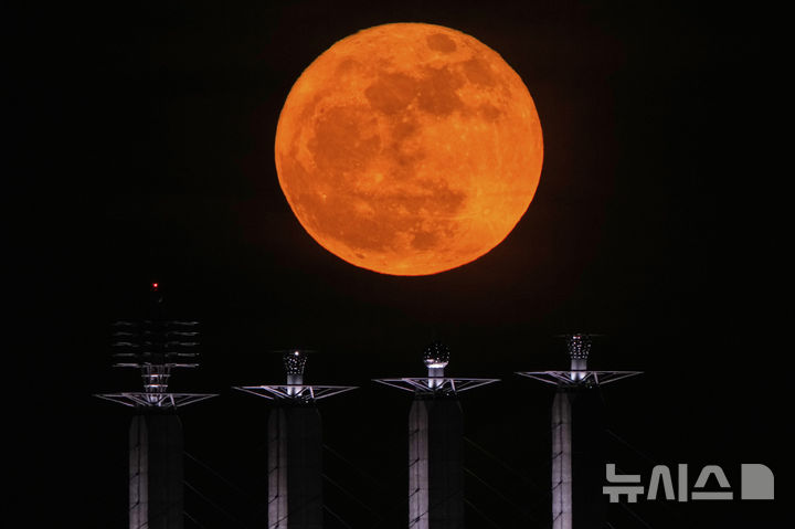 [캔자스시티=AP/뉴시스] 12일(현지 시간) 미 미주리주 캔자스시티 컨벤션 센터 옥상 조형물 뒤로 보름달이 떠오르고 있다. 2025.05.13.