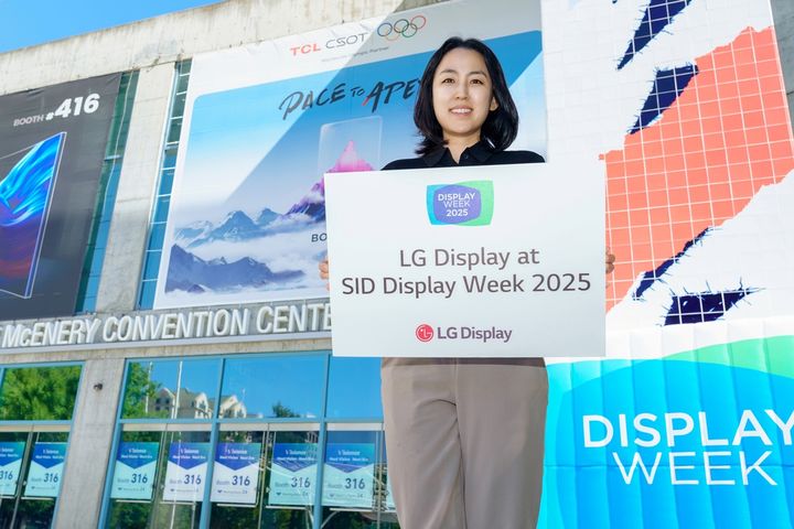 [서울=뉴시스]LG디스플레이 직원이 12일(현지시간) 세계 최대 디스플레이 전시회 'SID 2025'가 열리는 미국 새너제이 맥에너리컨벤션센터 앞에서 참가 소식을 알리고 있다. (사진=LG디스플레이 제공) 2025.05.13. photo@newsis.com *재판매 및 DB 금지