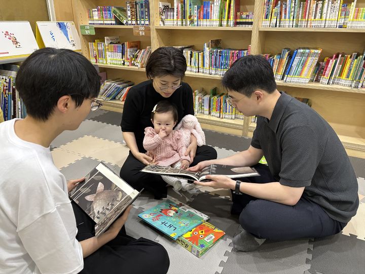 [서울=뉴시스] 위례동 주민모임 ‘북적북적’ 회원 들이 첫 활동에서 사용할 법 관련 동화를 읽고 있다. 2025.05.13 (사진 제공=송파구청) photo@newsis.com *재판매 및 DB 금지
