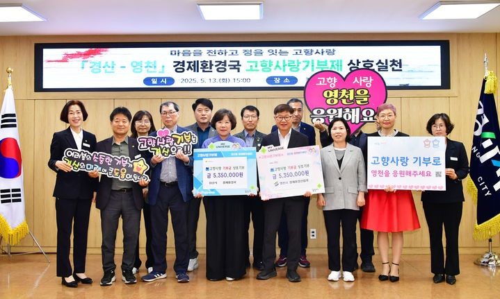[경산=뉴시스] 경북 경산시와 영천시 공무원들은 13일 경산시청에서 고향사랑기부금 535만원씩 상호 기탁하는 전달식을 가졌다. (사진=경산시 제공) 2025.05.13. photo@newsis.com *재판매 및 DB 금지