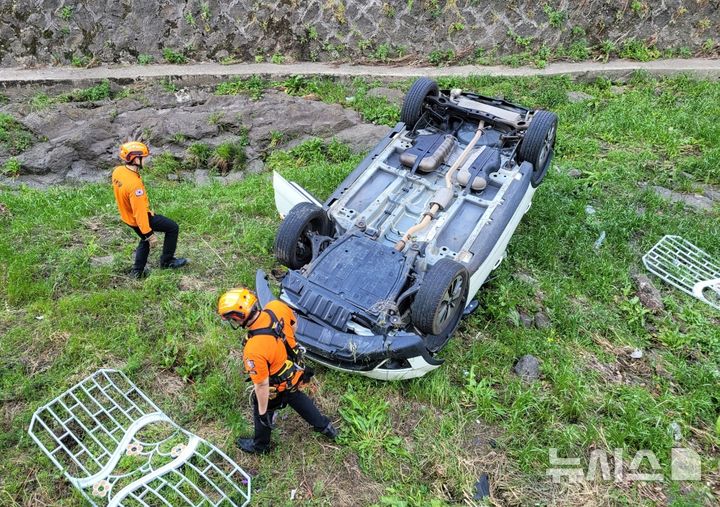 [제주=뉴시스] 13일 오후 제주시 노형동 한 도로에서 차량이 하천으로 추락해 소방당국이 탑승자 구조에 나서고 있다. (사진=제주소방안전본부 제공) 2025.05.13. photo@newsis.com