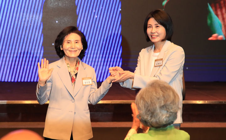 [서울=뉴시스] 조성봉 기자 = 이재명 더불어민주당 대선 후보의 부인 김혜경 여사와 김문수 국민의힘 대선후보의 부인 설난영 여사가 12일 서울 중구 신라호텔에서 열린 중앙신도회 창립 70주년 기념식에서 손을 맞잡고 있다.(사진=조계종 제공) 2025.05.13. photo@newsis.com *재판매 및 DB 금지