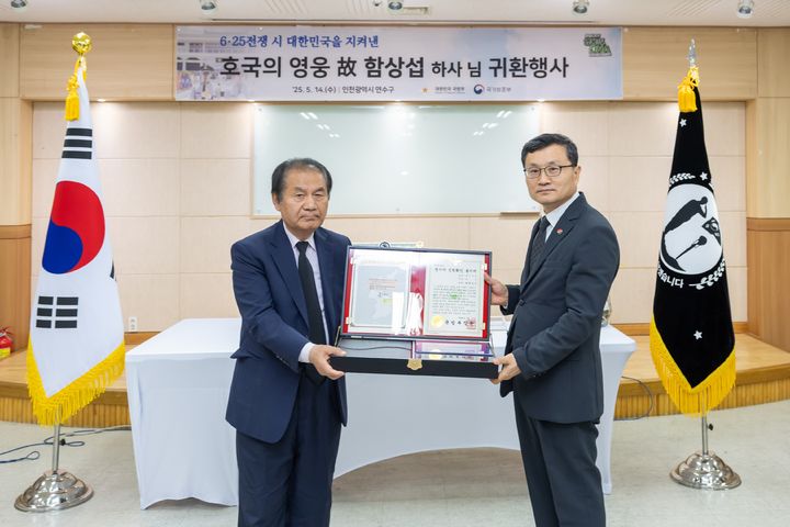 [서울=뉴시스] 이근원 국방부유해발굴감식단장이 유가족 대표인 아들 함재운 씨에게 고 함상섭 하사의 유품, 전사자 신원확인 통지서 등이 동봉된 호국의 얼 함을 전달하고 있다. (사진=국방부 제공) 2025.05.14. photo@newsis.com *재판매 및 DB 금지