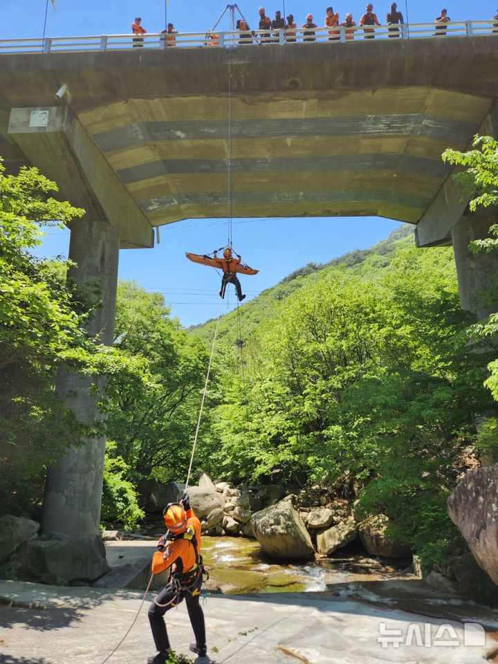 [창원=뉴시스]14일 경남 밀양시 산내면 가지산 일원에서경남119특수대응단과 밀양소방서 등 구조대원들이 추락사고 상황을 가정하여 30m 높이 직벽구조 훈련을 실시하고 있다.(사진=경남도소방본부 제공) 2025.05.14. photo@newsis.com