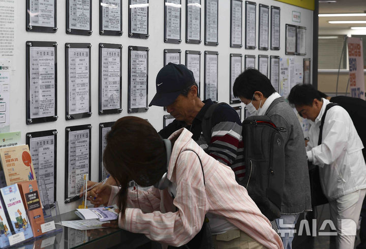 [서울=뉴시스] 김근수 기자 = 14일 서울 마포구 서부고용복지플러스센터 일자리 정보 게시판 앞에서 구직자들이 이력서를 작성하고 있다. 2025.05.14. ks@newsis.com