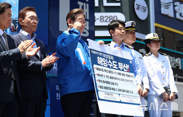 [부산=뉴시스] 권창회 기자 = 이재명 더불어민주당 대선 후보가 14일부산 부산진구 서면 젊음의 거리에서 열린 유세에서 권기흥 에이치라인해운해상직원노조 위원장과 해양수도 부산 협약서에 서명한 뒤 기념촬영을 하고 있다.2025.05.14. kch0523@newsis.com