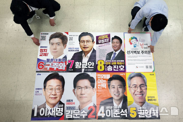 [서울=뉴시스] 김선웅 기자 = 제21대 대통령선거를 20일 앞둔 14일 서울 중구선거관리위원회에서 관계자들이 제출, 접수된 후보들의 선거벽보를 살펴보고 있다. (사진=공동취재) 2025.05.14. photo@newsis.com