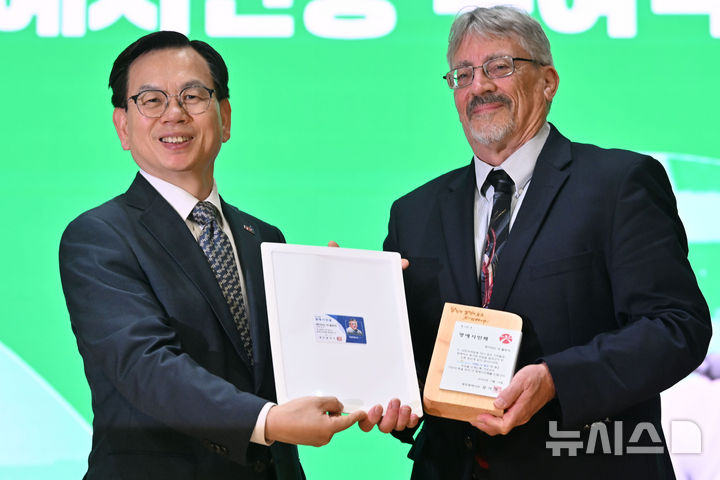 [광주=뉴시스] 이영주 기자 = 고광완(왼쪽) 광주시 행정부시장과 '푸른 눈의 5·18 시민군' 데이비드 돌린저(David L. Dolinger·72·한국명 임대운)가 14일 오후 광주 동구 전일빌딩 245에서 열린 데이비드 돌린저 광주 명예시민증 수여식 도중 기념사진을 촬영하고 있다. 데이비드 돌린저는 5·18민주화운동 당시 미국 평화봉사단원 신분으로 광주에 남아 시민군들과 함께 활동했다. 2025.05.14. leeyj2578@newsis.com