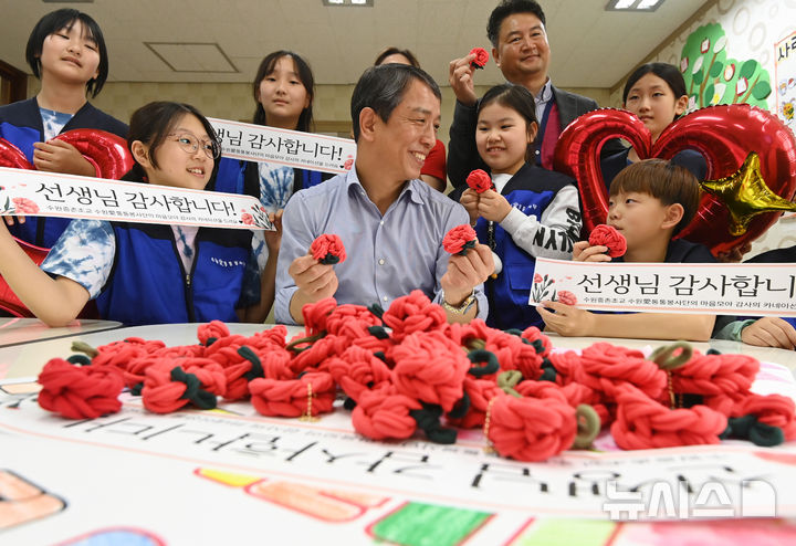 [수원=뉴시스] 김종택 기자 = 스승의 날을 하루 앞둔 14일 경기 수원시 권선구 중촌초등학교에서 통통봉사단 학생들이 직접 만든 카네이션과 감사의 편지를 선생님에게 전달하고 있다. 2025.05.14. jtk@newsis.com