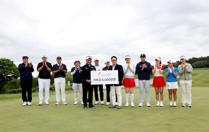 [서울=뉴시스]'SK텔레콤 채리티 오픈' 후원사인 아메리칸 익스프레스 코리아의 김유승 대표가 최경주 프로에게 기부금을 전달하고 있다. 뒷줄 왼쪽부터 김태균, 이대호, 박용택, 서경석, 이승민, 이경규, 김선영, 장유빈, 김하늘, 이보미, 최나연. (사진 = SK텔레콤오픈2025 제공) 2025.05.15. photo@newsis.com *재판매 및 DB 금지
