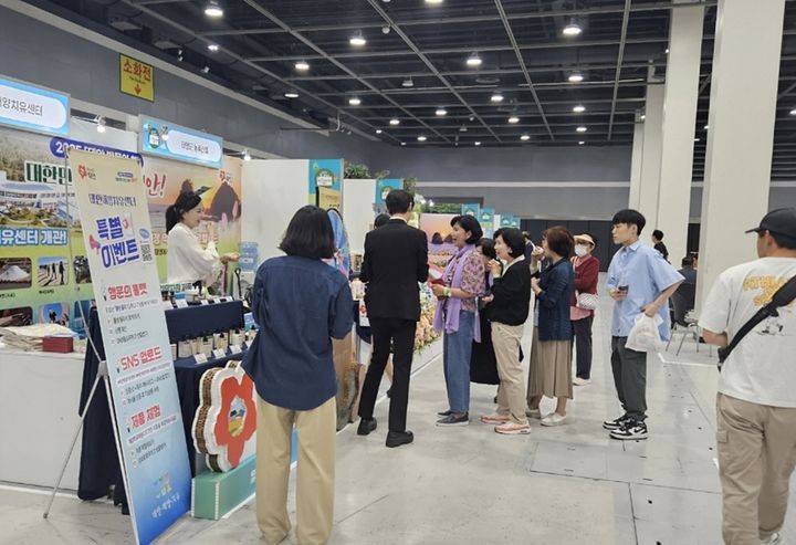 [태안=뉴시스] 14일 서울 aT센터에서 진행된 ‘2025 K-웰니스 푸드&투어리즘 페어’ 행사장에 마련된 태안군 부스에 들른 관람객이 이벤트 등을 즐기고 있다. (사진=태안군 제공) 2025.05.15. photo@newsis.com *재판매 및 DB 금지