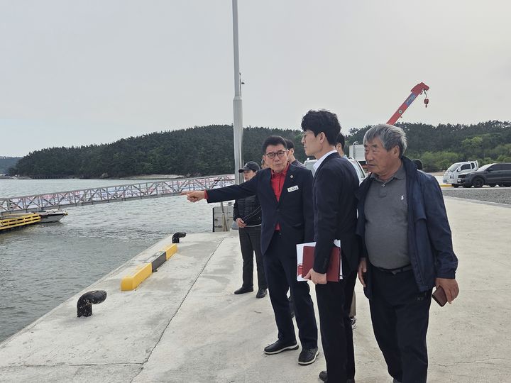 [홍성=뉴시스] 정광섭 충남도의원이 태안군 만대항을 찾아 손으로 바닷물 침수 등의 문제점을 지적하고 있다.&nbsp;&nbsp; *재판매 및 DB 금지