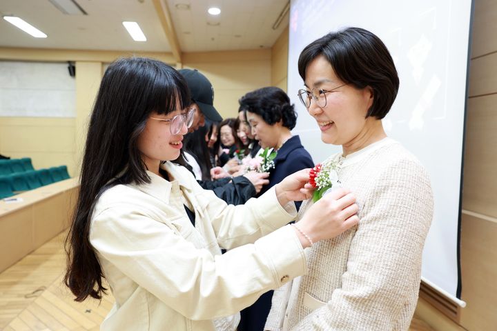 외국인 유학생이 강사에게 카네이션을 달아주고 있다. (사진=삼육대 제공) *재판매 및 DB 금지