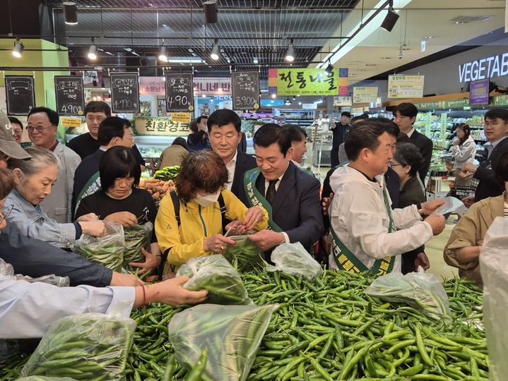 [밀양=뉴시스] 곽근석 부시장이 풋고추 소비 촉진 행사에서 청양고추 한 봉지 가득 담기 이벤트를 진행하고 있다. (사진=밀양시 제공) 2025.05.15. photo@newsis.com *재판매 및 DB 금지