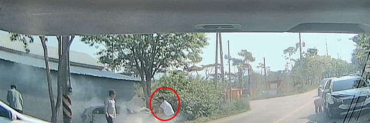 [정읍=뉴시스] 지난 14일 전북 정읍시 북면의 한 마을 앞 도로에서 발생한 교통사고로 모닝 차량에서 연기가 피어오르자 출근길 이를 목격한 정읍소방서 한호희 소방사(빨간 원)가 소화기로 연기를 진압하고 있다. (사진=전북특별자치도소방본부 제공) 2025.05.15. photo@newsis.com *재판매 및 DB 금지