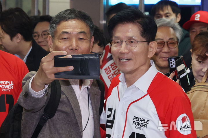 [서울=뉴시스] 조성봉 기자= 김문수 국민의힘 대선후보가 15일 오전 서울 구로구 신도림역에서 출근길 시민과 셀카를 찍고 있다. (공동취재) 2025.05.15. photo@newsis.com