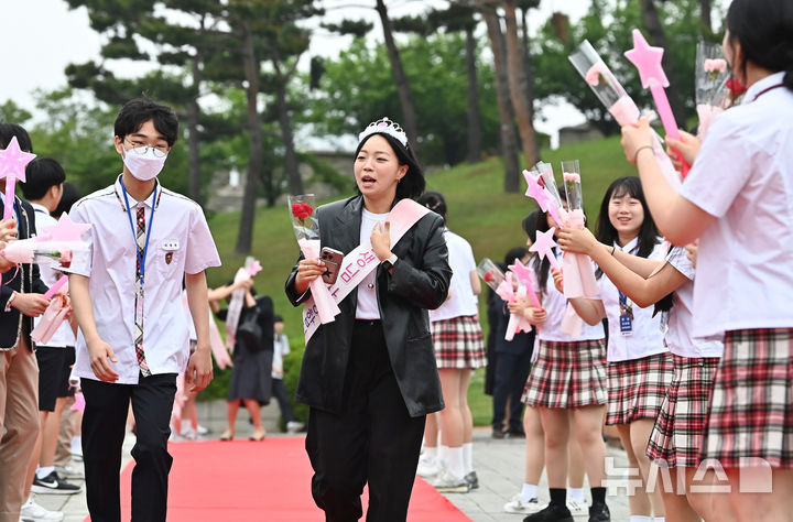 [수원=뉴시스] 김종택 기자 = 스승의날인 15일 경기 수원시 팔달구 매향중학교에서 선생님들이 레드카펫을 걸으며 학생들의 축하와 카네이션을 받고 있다. 2025.05.15. jtk@newsis.com