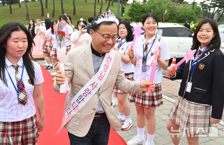 [수원=뉴시스] 김종택 기자 = 스승의날인 15일 경기 수원시 팔달구 매향중학교에서 선생님들이 레드카펫을 걸으며 학생들의 축하와 카네이션을 받고 있다. 2025.05.15. jtk@newsis.com