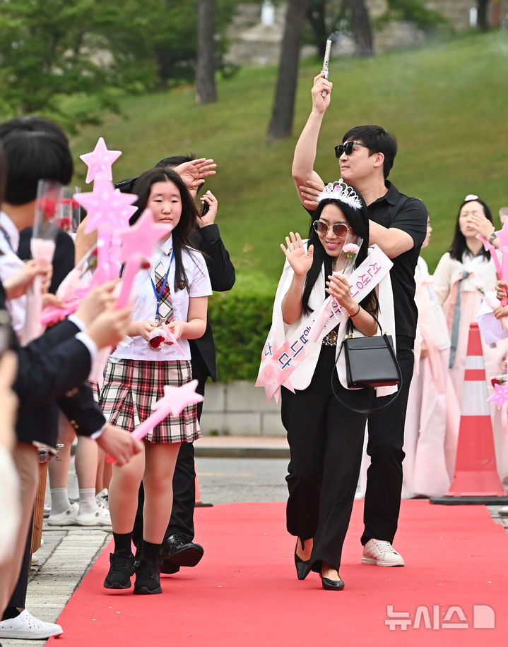 [수원=뉴시스] 김종택 기자 = 스승의날인 15일 경기 수원시 팔달구 매향중학교에서 선생님들이 레드카펫을 걸으며 학생들의 축하와 카네이션을 받고 있다. 2025.05.15. jtk@newsis.com