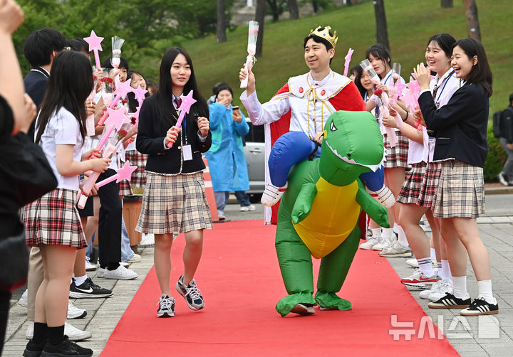 [수원=뉴시스] 김종택 기자 = 스승의날인 15일 경기 수원시 팔달구 매향중학교에서 선생님이 레드카펫을 걸으며 학생들의 축하와 카네이션을 받고 있다. 2025.05.15. jtk@newsis.com