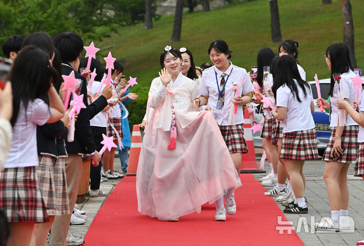 [수원=뉴시스] 김종택 기자 = 스승의날인 15일 경기 수원시 팔달구 매향중학교에서 선생님들이 레드카펫을 걸으며 학생들의 축하와 카네이션을 받고 있다. 2025.05.15. jtk@newsis.com