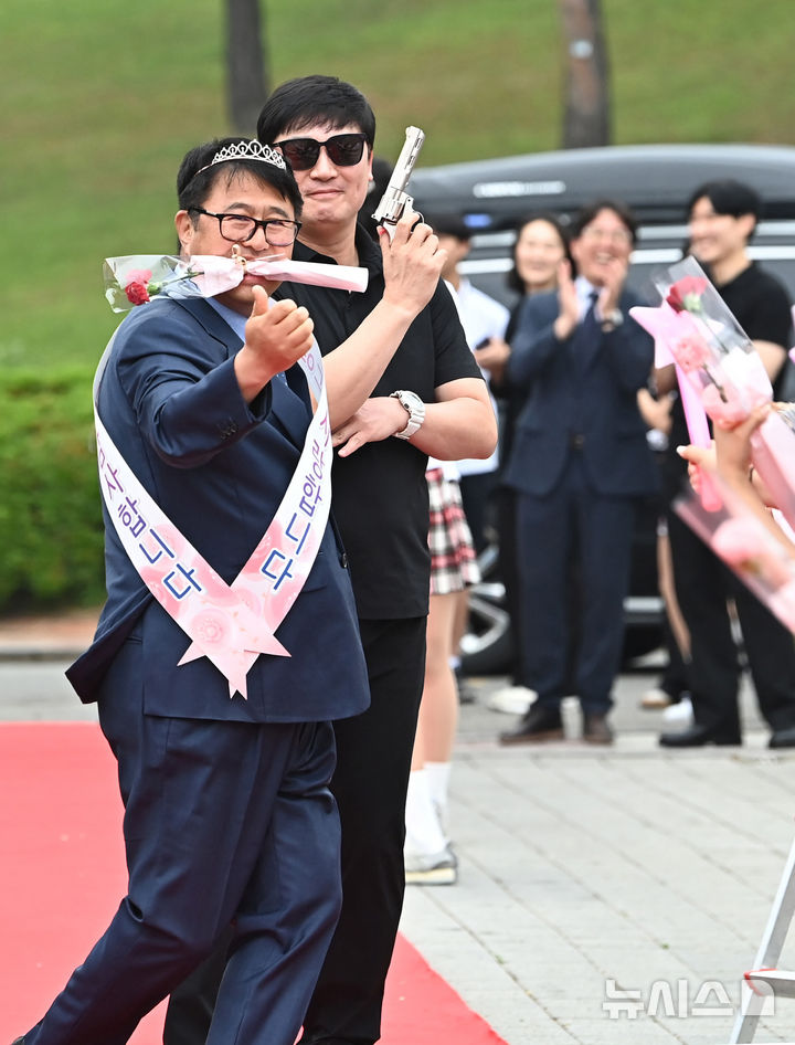 [수원=뉴시스] 김종택 기자 = 스승의날인 15일 경기 수원시 팔달구 매향중학교에서 선생님들이 레드카펫을 걸으며 학생들의 축하와 카네이션을 받고 있다. 2025.05.15. jtk@newsis.com