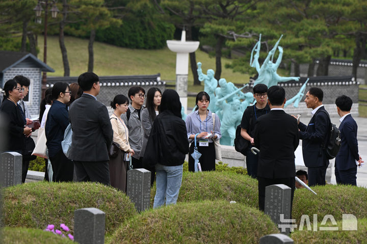 [광주=뉴시스] 박기웅 기자 = 광주전남기자협회와 한국언론진흥재단 주최로 열린 전국 언론인 대상 5·18역사기행에 참여한 언론인들이 15일 오전 광주 북구 운정동 국립5·18민주묘지를 방문해 해설사로부터 설명을 듣고 있다. 2025.05.15. pboxer@newsis.com