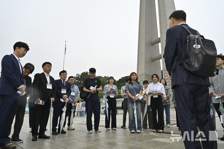 [광주=뉴시스] 박기웅 기자 = 광주전남기자협회와 한국언론진흥재단 주최로 열린 전국 언론인 대상 5·18역사기행에 참여한 언론인들이 15일 오전 광주 북구 운정동 국립5·18민주묘지를 방문해 해설사로부터 설명을 듣고 있다. 2025.05.15. pboxer@newsis.com