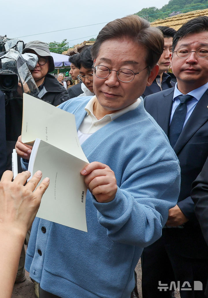 [하동=뉴시스] 권창회 기자 =이재명 더불어민주당 대선 후보가 15일 경남 하동군 화개장터 입구에서 유튜브 'K-이니셔TV 케미폭발 동서화합 화개장터 라이브'를 마치고 이동하며 지지자들에게 사인을 해주고 있다. (공동취재) 2025.05.15. photo@newsis.com