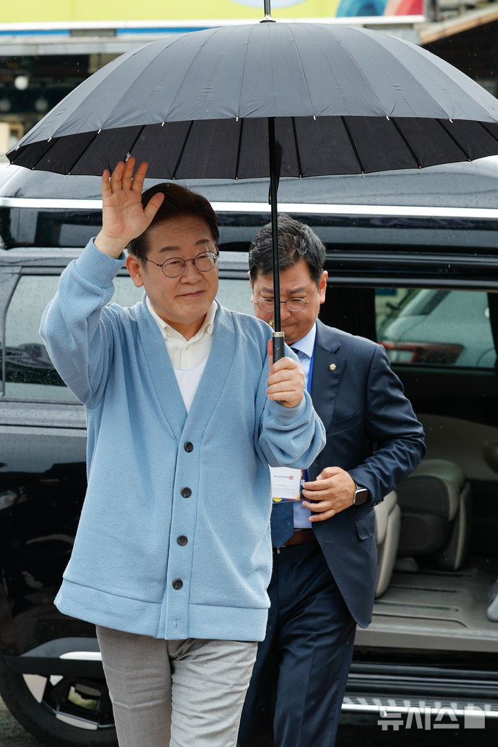[하동=뉴시스] 권창회 기자 =이재명 더불어민주당 대선 후보가 15일 경남 하동군 화개장터 입구에서 유튜브 'K-이니셔TV 케미폭발 동서화합 화개장터 라이브'를 하기 위해 차에서 내려 인사하고 있다. (공동취재) 2025.05.15. photo@newsis.com