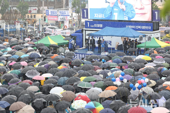 [여수=뉴시스] 권창회 기자 = 이재명 더불어민주당 대선 후보가 15일 전남 여수시 이순신광장에서 열린 집중유세에서 연설을 하는 가운데 시민들이 우산을 쓰고 이 후보 연설을 듣고 있다. (공동취재) 2025.05.15. photo@newsis.com