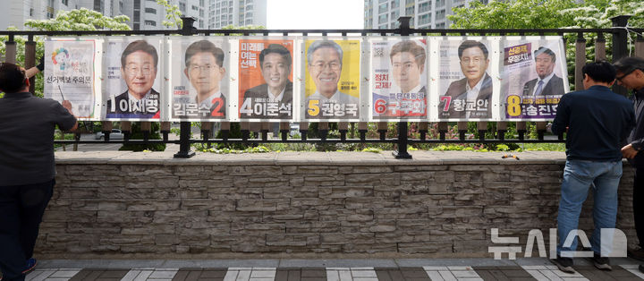 [인천=뉴시스] 전진환 기자 = 15일 오후 인천 동구의 한 아파트 담장에서 송림 3,5동 행정복지센터 관계자들이 제21대 대통령선거 선거벽보를 부착하고 있다. 2025.05.15. amin2@newsis.com