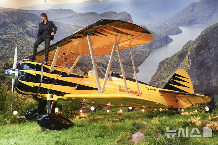 [런던=AP/뉴시스] 배우 톰 크루즈가 15일(현지 시간) 영국 런던에서 열린 영화 '미션 임파서블: 파이널 레코닝' 시사회에 참석해 비행기 세트 위에 올라가 포즈를 취하고 있다. 2025.05.16.