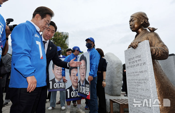 [익산=뉴시스] 조성우 기자 = 지난달 16일 당시 대선후보였던 이재명 대통령이 전북 익산시 익산역 동부광장에서 열린 유세에 참석하며 평화의 소녀상을 보고 있다. (공동취재) 2025.05.16. photo@newsis.com