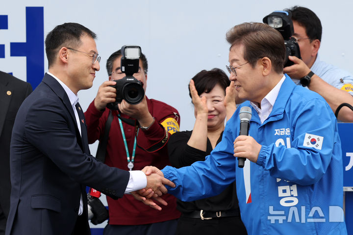 [익산=뉴시스] 조성우 기자 = 이재명 더불어민주당 대선후보가 16일 전북 익산시 익산역 동부광장에서 열린 유세에서 자신의 지지를 선언한 김상욱 무소속 의원과 악수하고 있다. (공동취재) 2025.05.16. photo@newsis.com