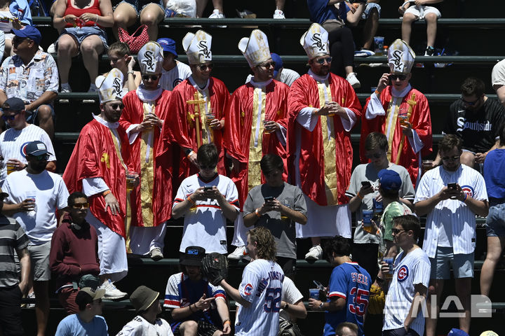 [시카고=AP/뉴시스] 시카고 화이트삭스 팬들이 17일(한국 시간) 미국 일리노이주 시카고의 리글리 필드에서 열린 2025 메이저리그(MLB) 시카고 컵스와의 경기에서 교황 복장을 한 채 응원전을 펼치고 있다. 2025.05.17