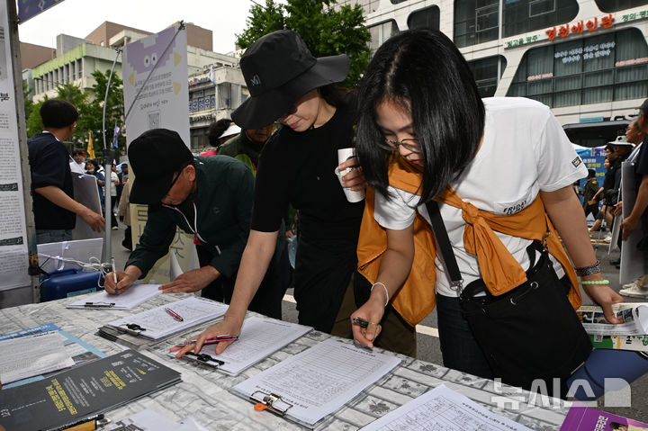[광주=뉴시스] 이영주 기자 = 17일 오후 광주 동구 금남로에서 열린 5·18민주화운동 45주기 전야행사 오월시민난장에 참여한 시민들이 내란수괴 전두환의 아호를 본따 이름붙여진 일해공원의 명칭 변경을 촉구하는 서명운동에 동참하고 있다. 2025.05.17. leeyj2578@newsis.com