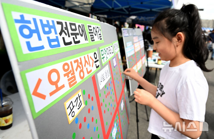 [광주=뉴시스] 김혜인 기자 = 5·18민주화운동 45주년 전야제 부스가 마련된 17일 오후 광주 동구 금남로에서 한 아동이 5·18정신 헌법 전문 수록 관련 투표를 하고 있다. 2025.05.17. hyein0342@newsis.com