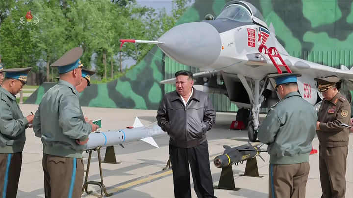 [서울=뉴시스] = 김정은 북한 국무위원장이 지난 15일 제1공군사단 관하 비행연대를 시찰하면서 공개한 첨단능동레이더공대공미사일(AAM)이 김정은 오른팔 옆에 설치돼 있다. 그러나 뒷면의 미그-29 오른쪽 날개 아래에 장착된 이 미사일 모습은 포토샵으로 엉성하게 붙인 것이다. (사진 = 조선중앙TV 캡처) 2025.5.23. photo@newsis.com *재판매 및 DB 금지