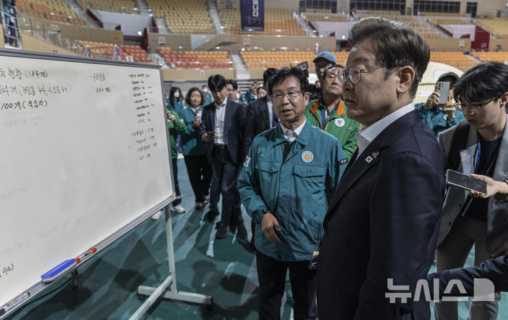 [광주=뉴시스] 조성우 기자 = 이재명 더불어민주당 대선후보가 17일 광주 광산구 광주여자대학교 유니버시아드 체육관에 마련된 금호타이어 공장 화재 대피소를 찾아 박병규 광산구청장의 현황 설명을 듣고 있다. (공동취재) 2025.05.17. photo@newsis.com
