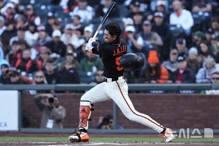 [샌프란시스코=AP/뉴시스] 샌프란시스코 자이언츠의 이정후가 17일(현지 시간) 미 캘리포니아주 샌프란시스코의 오라클 파크에서 열린 2025 메이저리그 애슬레틱스와의 경기 1회말 배트를 휘두르다 헬멧이 벗겨지고 있다. 2025.05.18.
