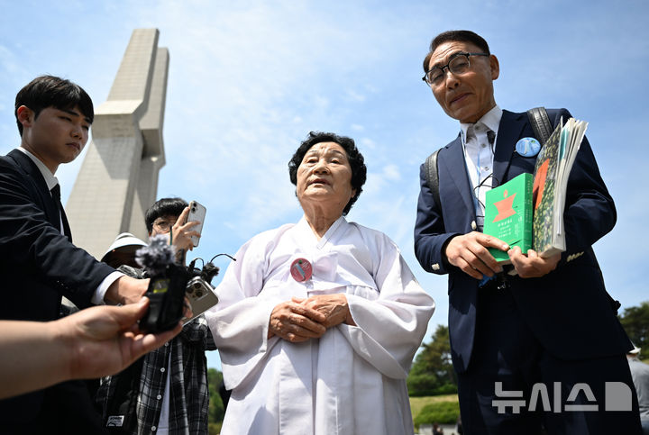 [광주=뉴시스] 김혜인 기자 = 광주5·18민주화운동 45주년 기념식이 열린 18일 오전 광주 북구 운정동 국립 5·18민주묘지에서 문재학 열사 어머니가 한국현대사연구회 소속 일본인들에게 열사의 삶을 설명하고 있다. 2025.05.18. hyein0342@newsis.com