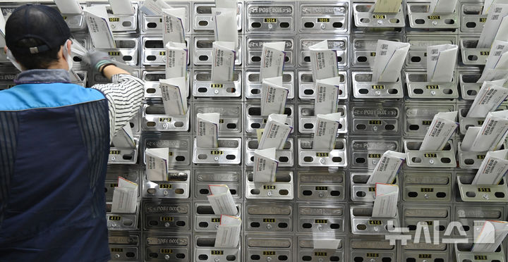 [수원=뉴시스] 김종택 기자 = 지난해 5월 18일 경기 수원시 권선구 한 오피스텔 건물에서 우체국 집배원이 우편물을 우편함에 넣고 있다. 2025.05.18. jtk@newsis.com *기사 내용과 직접 관련 없음