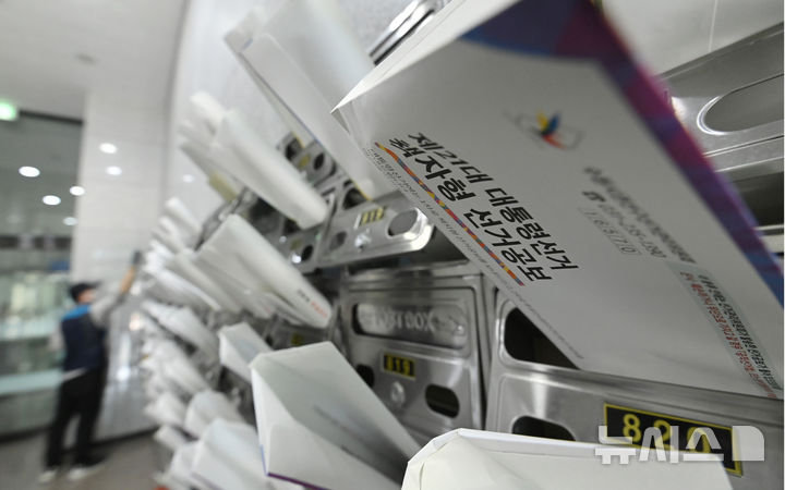 [수원=뉴시스] 김종택 기자 = 18일 경기 수원시 권선구 한 오피스텔 건물에서 우체국 집배원이 제21대 대통령선거 안내문과 선거공보물을 우편함에 넣고 있다. 2025.05.18. jtk@newsis.com