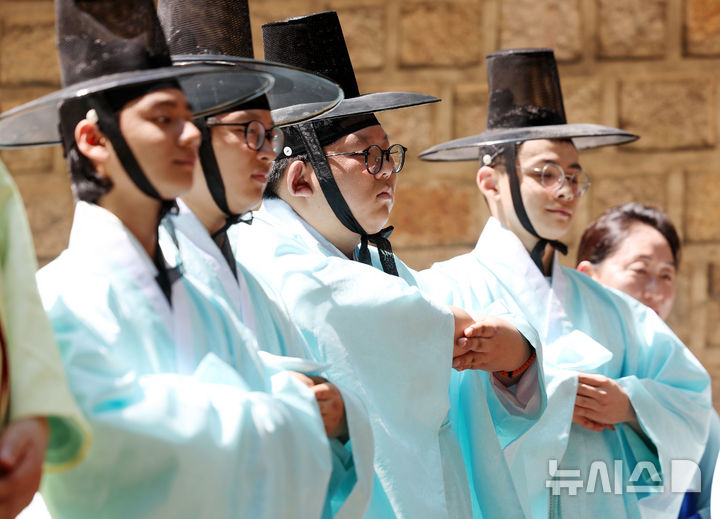 [서울=뉴시스] 김진아 기자 = 성년의 날을 하루 앞둔 19일 서울 중구 덕수궁돌담길에서 열린 제53회 서울시 성년의 날 축제에서 청소년들이 전통성년례를 재현하고 있다. 2025.05.18. bluesoda@newsis.com