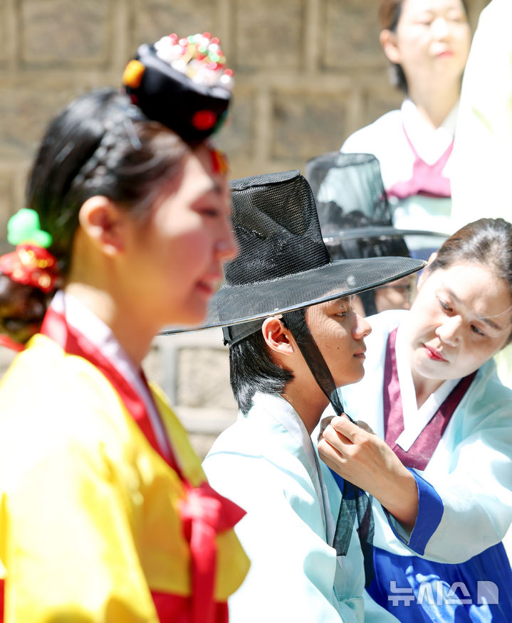 [서울=뉴시스] 김진아 기자 = 성년의 날을 하루 앞둔 19일 서울 중구 덕수궁돌담길에서 열린 제53회 서울시 성년의 날 축제에서 청소년들이 전통성년례를 재현하고 있다. 2025.05.18. bluesoda@newsis.com