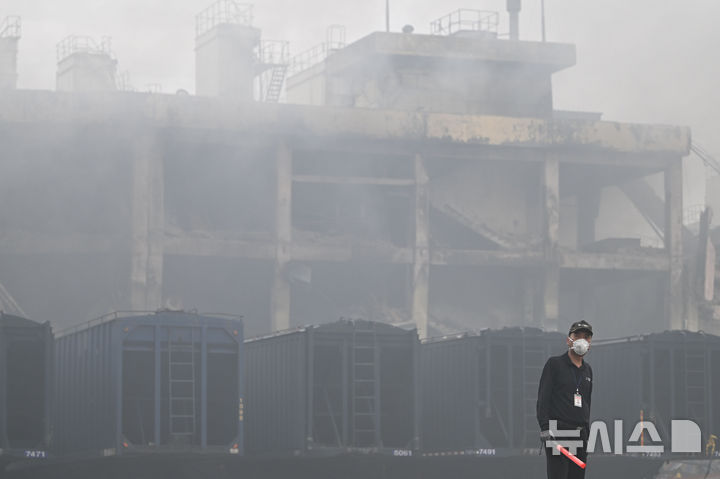 [광주=뉴시스] 이영주 기자 = 금호타이어 광주공장 화재 사흘째인 19일 오전 광주 광산구 금호타이어 2공장에서 경비원이 망연자실한 표정을 짓고 있다. 2025.05.19. leeyj2578@newsis.com